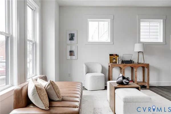 a living room with furniture a large window and a dining table