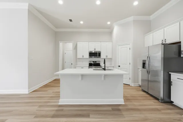 a kitchen with white cabinets stainless steel appliances and sink