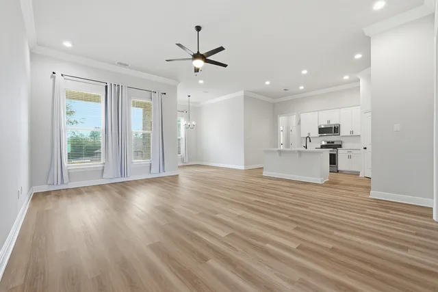 a view of a livingroom with wooden floor and a ceiling fan