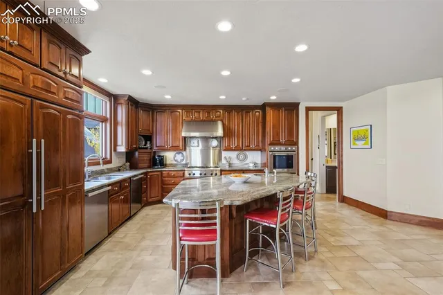 a kitchen with stainless steel appliances granite countertop wooden cabinets a sink and a stove