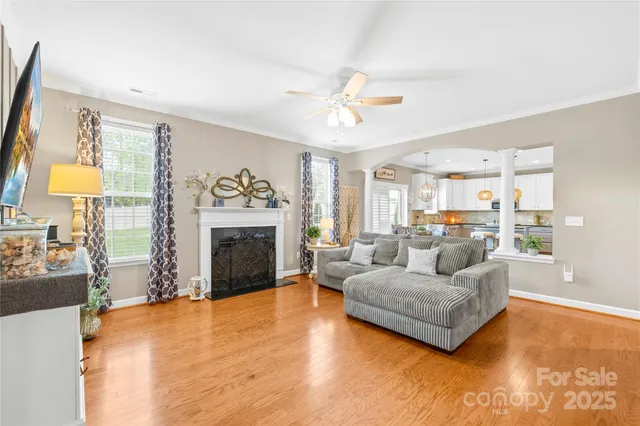 a living room with furniture a chandelier and a flat screen tv