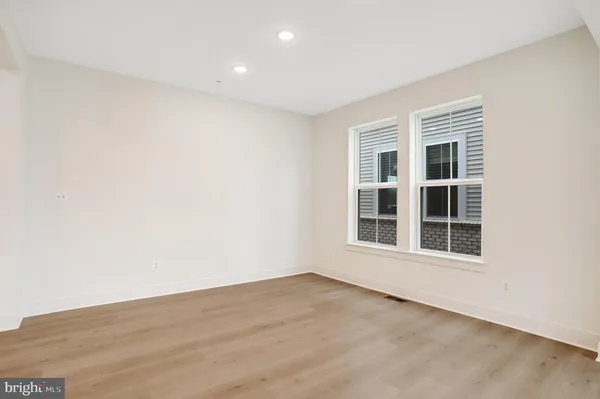 an empty room with windows and fireplace
