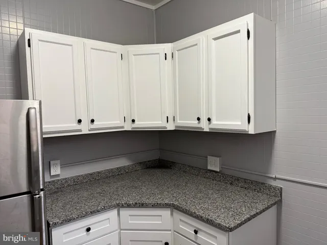 a kitchen with granite countertop a sink and cabinets