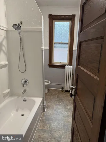 a bathroom with a tub a sink and a window