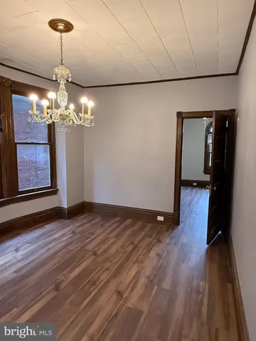 a view of a room with wooden floor chandelier and closet