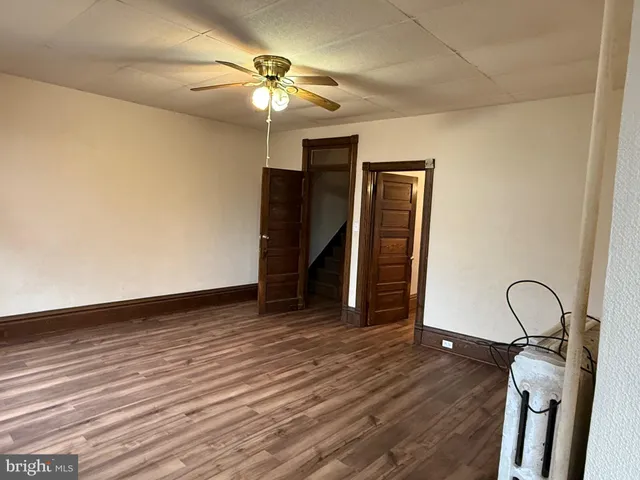 a view of a room with wooden floor and ceiling fan