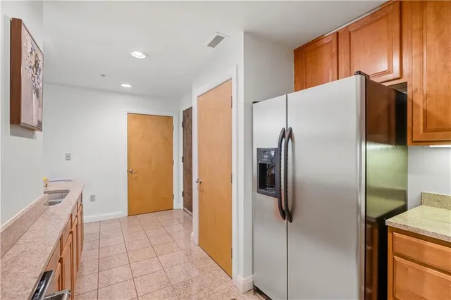 a metallic refrigerator freezer sitting in a kitchen