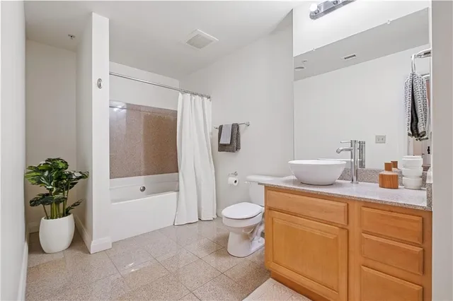 a bathroom with a granite countertop sink a toilet and shower