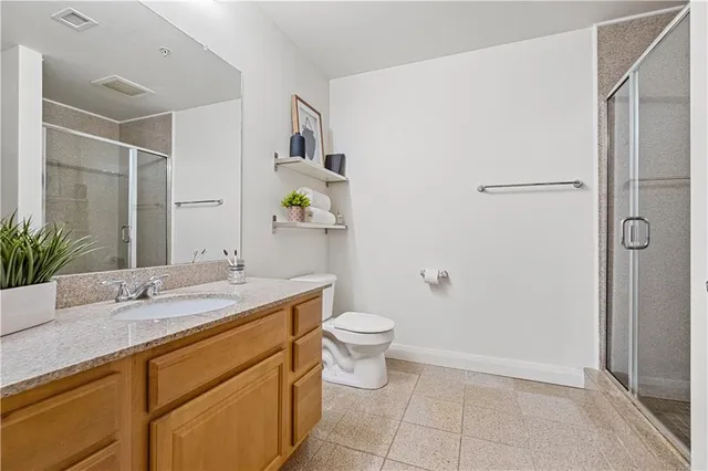 a bathroom with a granite countertop sink a toilet and shower