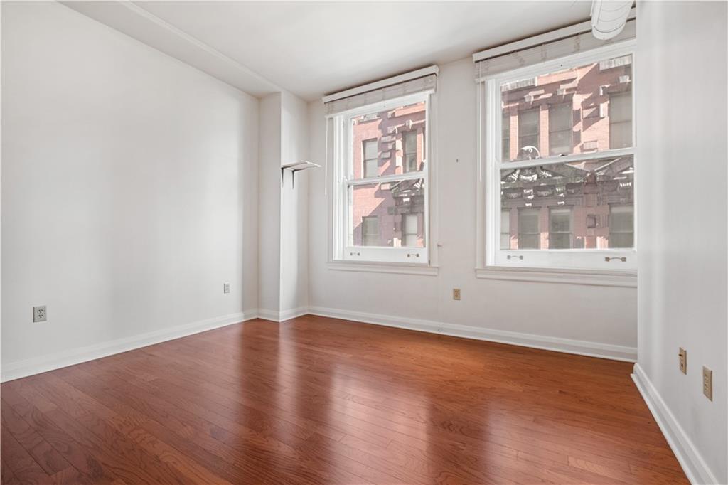 306 Fourth Avenue, Unit 501 Pittsburgh, PA 15222 - Photo 26 of 30 an empty room with wooden floor and windows