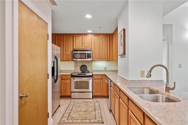 a kitchen with stainless steel appliances granite countertop a sink stove and refrigerator