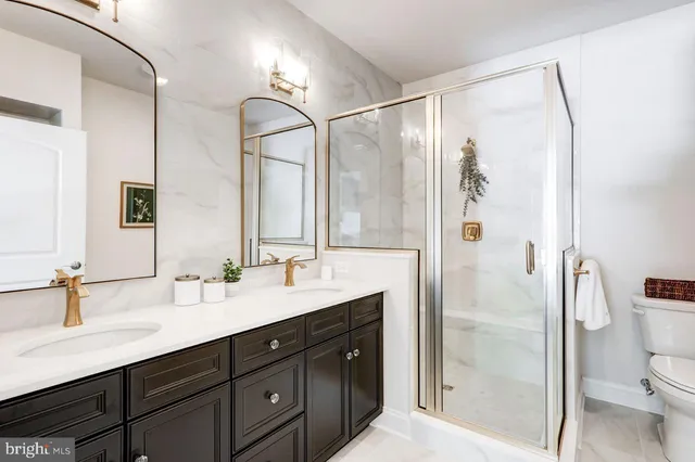 a bathroom with a double vanity sink mirror double and shower