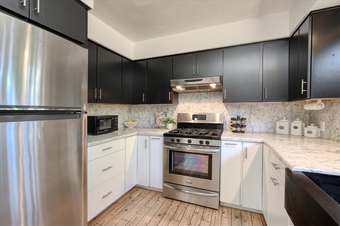 798 Drake Street Cambria, CA 93428 - Photo 14 of 45 a kitchen with cabinets stainless steel appliances and wooden floor