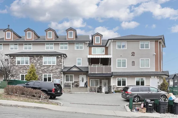 a front view of a residential apartment building with a yard