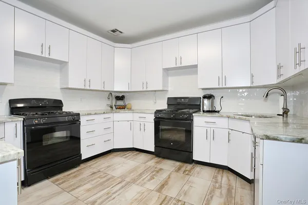 a kitchen with granite countertop white cabinets and appliances