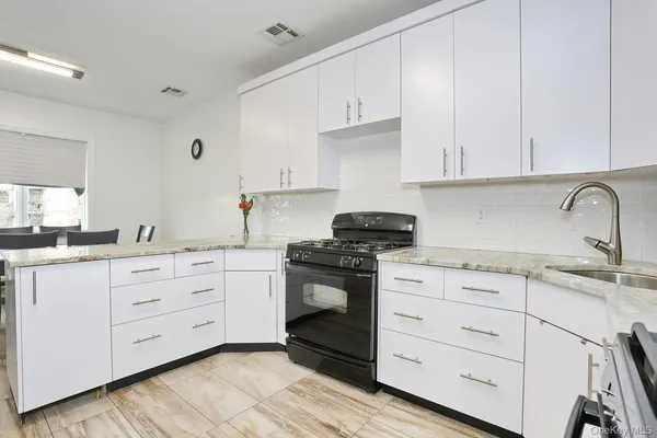 a kitchen with granite countertop white cabinets and white appliances
