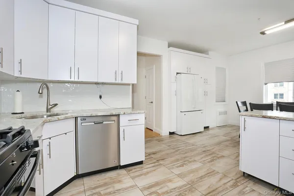 a kitchen with granite countertop white cabinets and white appliances