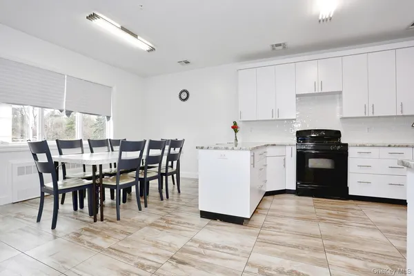 a kitchen with a dining table chairs and white appliances