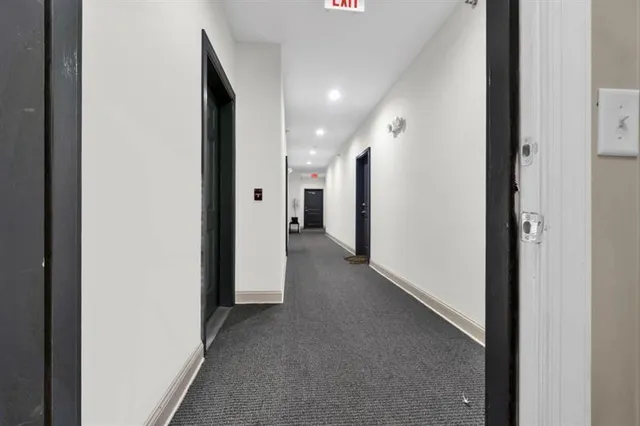 a view of a hallway with closet and wooden floor