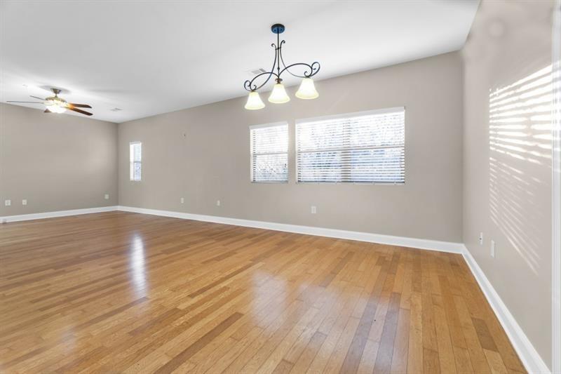2230 Cheshire Bridge Road Northeast, Unit 412 Atlanta, GA 30324 - Photo 4 of 35 an empty room with wooden floor chandelier fan and windows