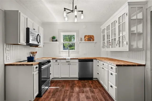 a kitchen with granite countertop a sink stove and cabinets