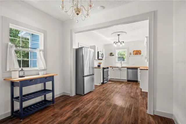 a kitchen with stainless steel appliances a refrigerator and a wooden floor