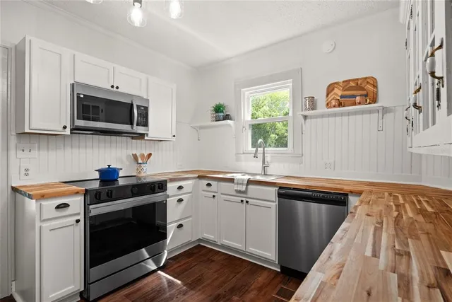 a kitchen with granite countertop cabinets stainless steel appliances and a window