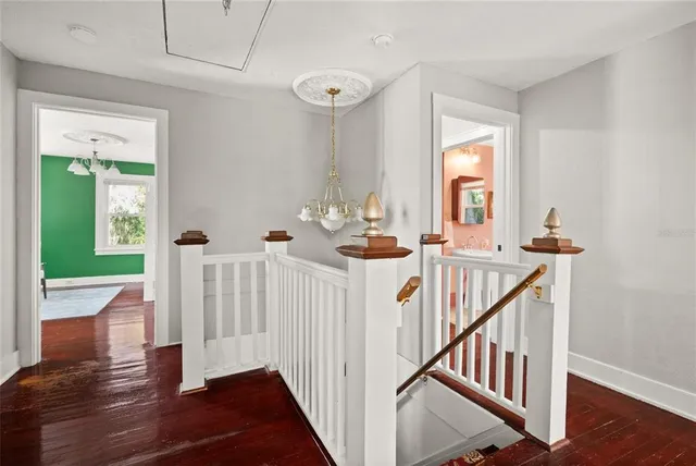 a view of a hallway with wooden floor and stairs