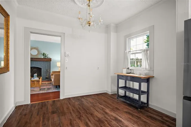 a furnished dining room with a window and wooden floor