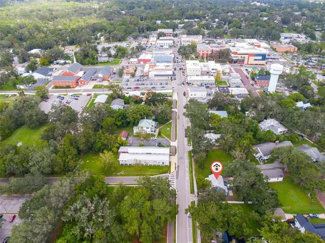an aerial view of residential house with outdoor space and trees