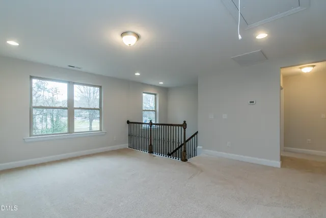 an empty room with fan and windows