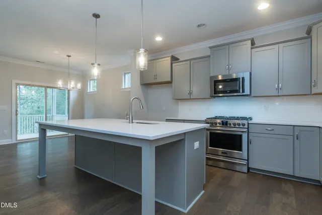 a kitchen with kitchen island a sink stainless steel appliances and cabinets