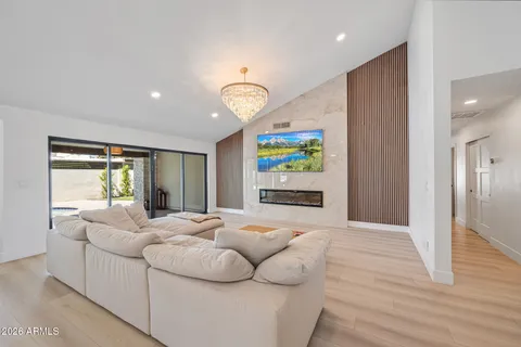 a living room with a large window and a chandelier