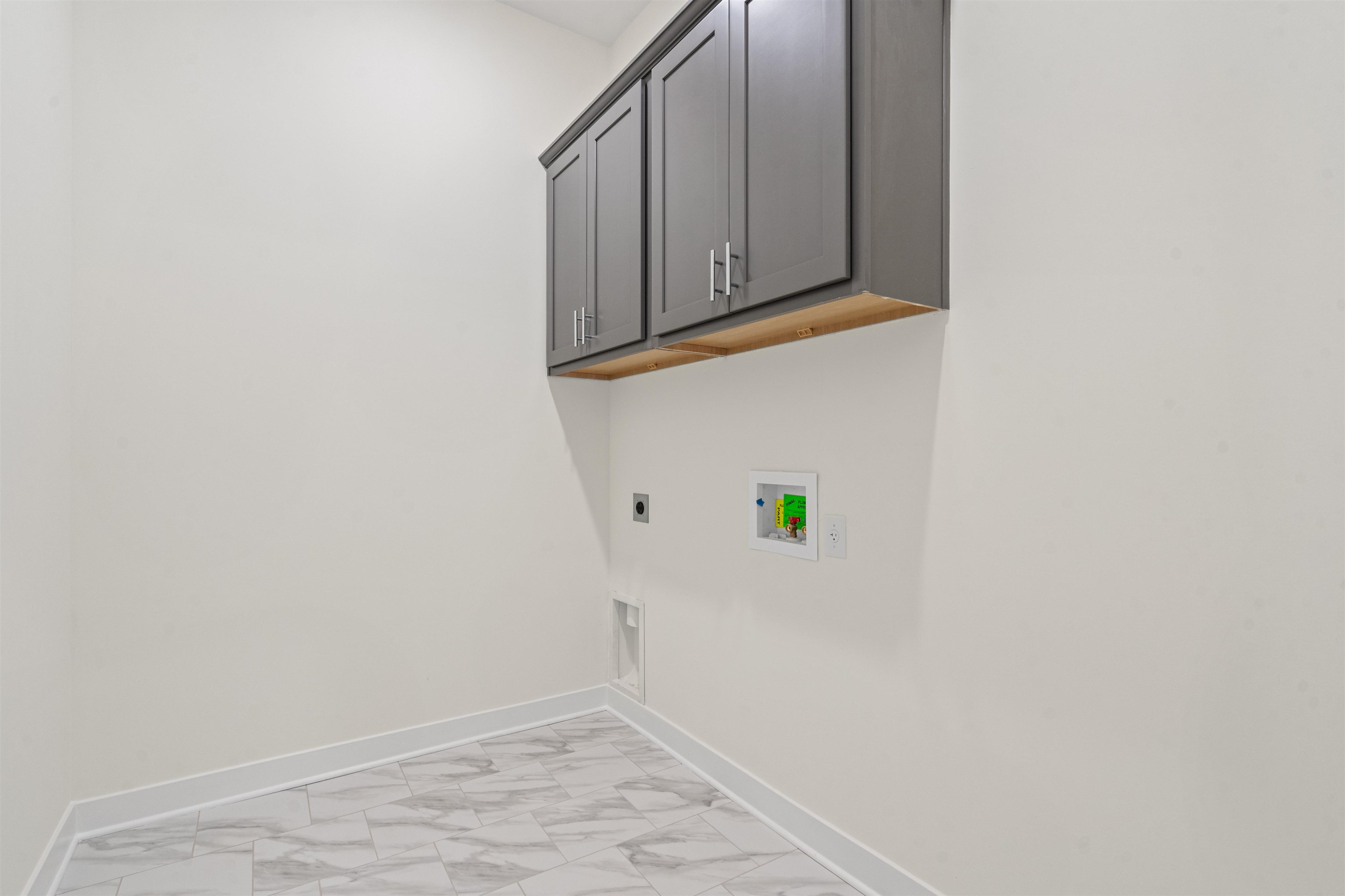 5666 Pleasant Pk Place Arlington, TN 38002 - Photo 9 of 27 Laundry area featuring gray shaker cabinetry with brushed nickel hardware, white walls, and a white and gray patterned tile floor