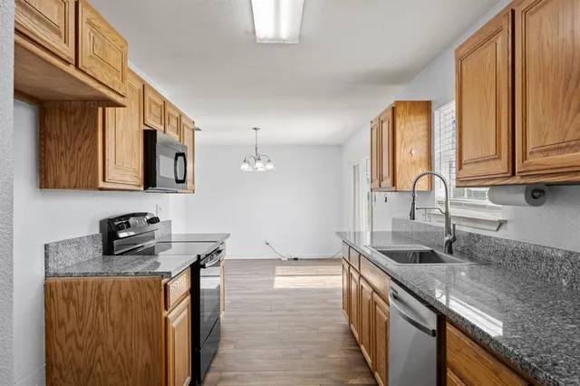 a kitchen with stainless steel appliances granite countertop a sink stove and cabinets