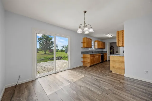 a view of a kitchen with a sink and dishwasher with wooden floor