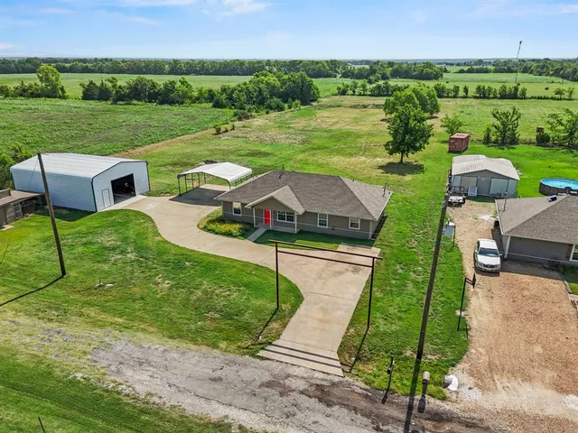 an aerial view of a house with big yard