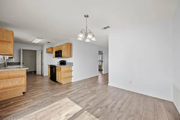 a view of kitchen with granite countertop cabinets and refrigerator