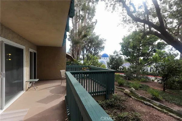 a balcony with wooden floor and trees