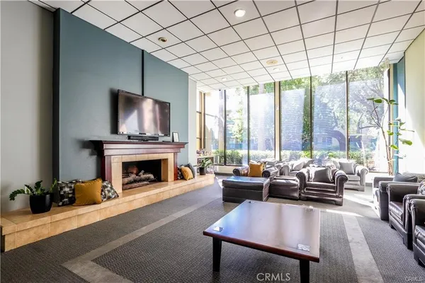 a living room with furniture large windows and a fireplace