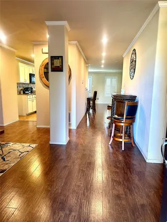 a view of a room with wooden floor kitchen view and a window