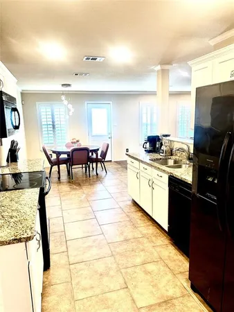 a kitchen with stainless steel appliances granite countertop a stove a sink a microwave and a dining table