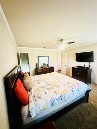 a bed sitting in a bedroom and a flat screen tv