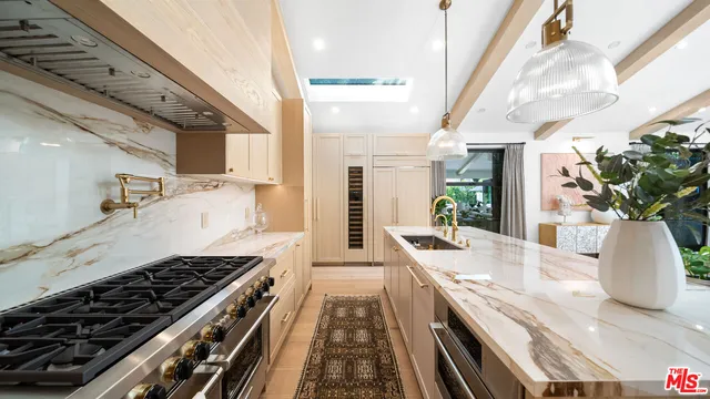 a large kitchen with stainless steel appliances kitchen island granite countertop a lot of counter space and wooden floor