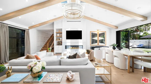 a living room with furniture a flat screen tv and a large window