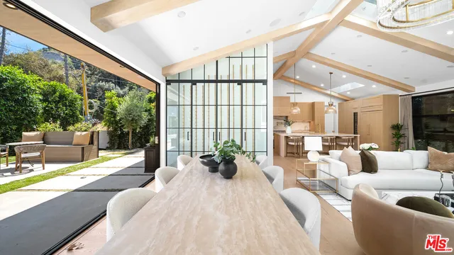 a living room with furniture large windows and wooden floor