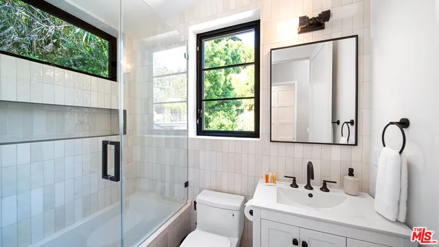 a bathroom with a sink a toilet and a mirror