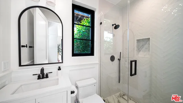 a bathroom with a sink a toilet and a mirror