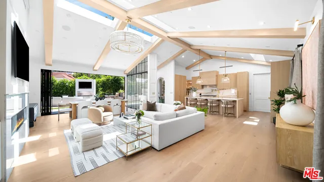 a living room with furniture wooden floor and a large window