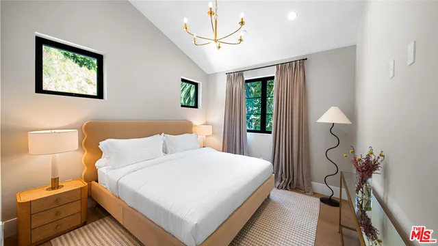 a bedroom with a bed and a chandelier